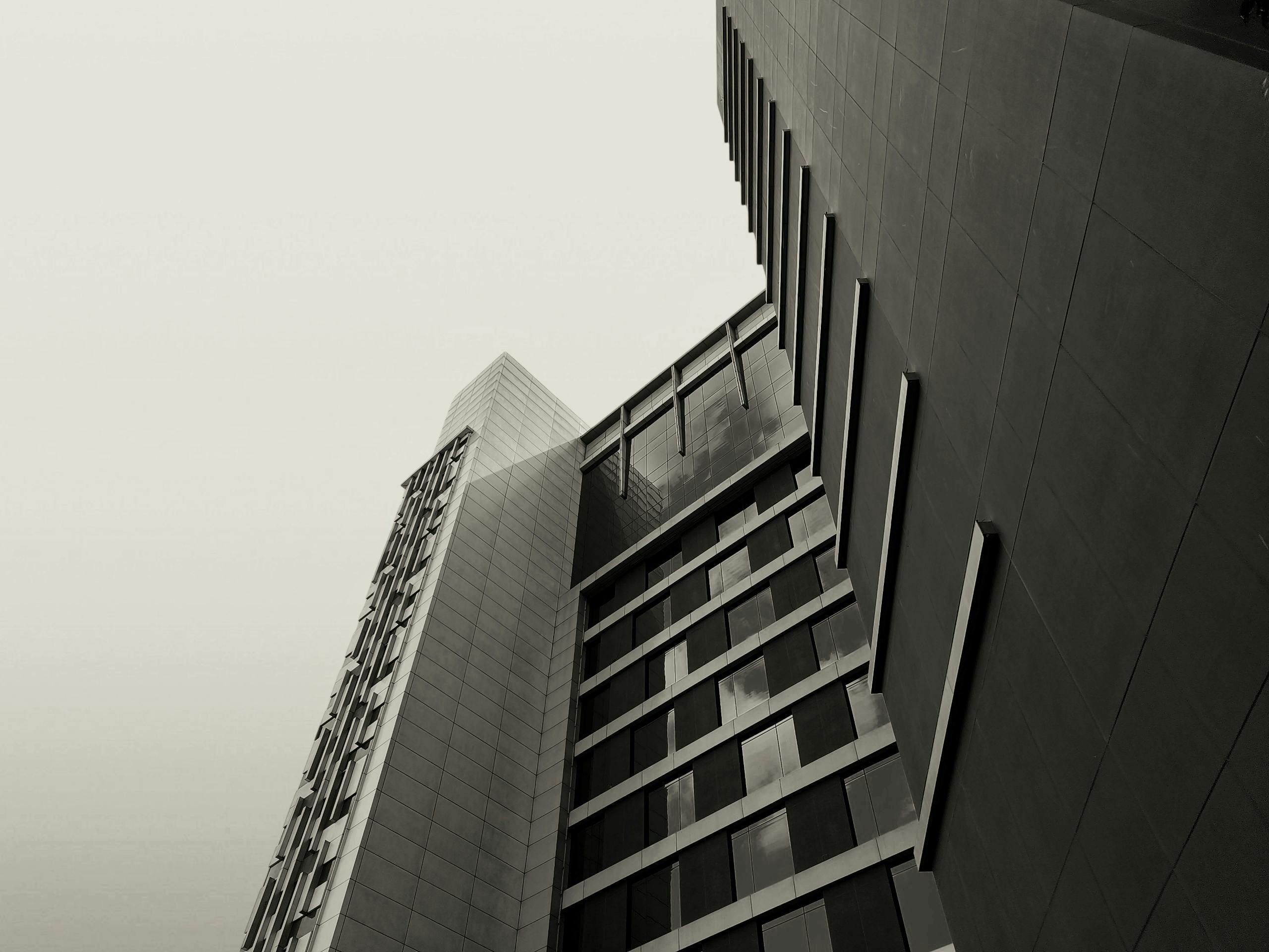 Black and white photo of a modern high-rise building showcasing an architectural perspective.